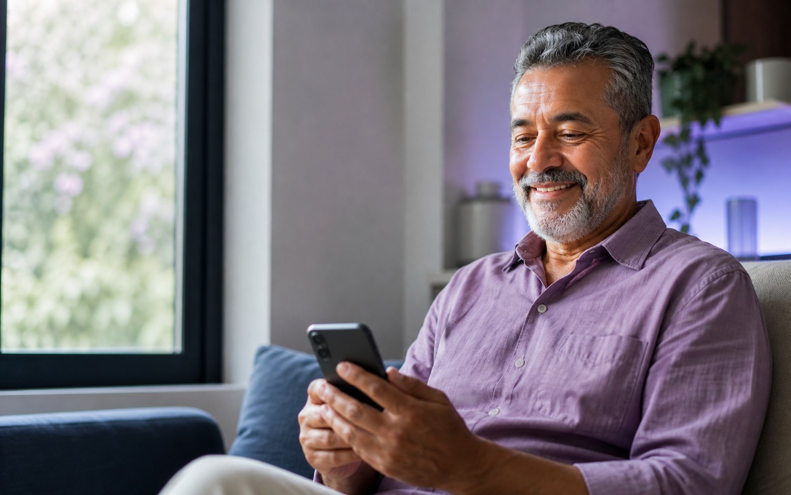Homem usando o celular com tranquilidade em casa
