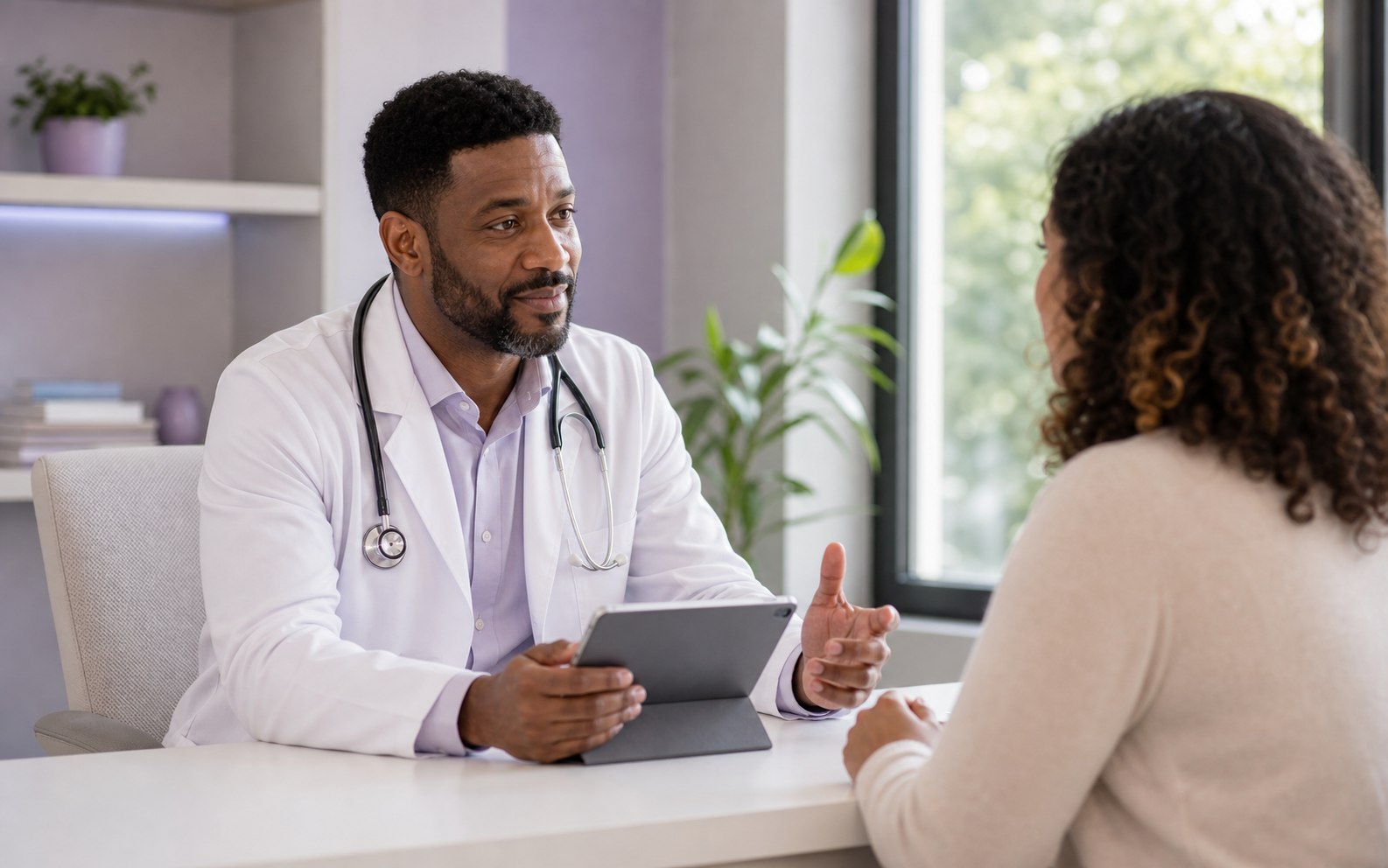 Médico negro conversando com uma paciente em uma consulta acolhedora